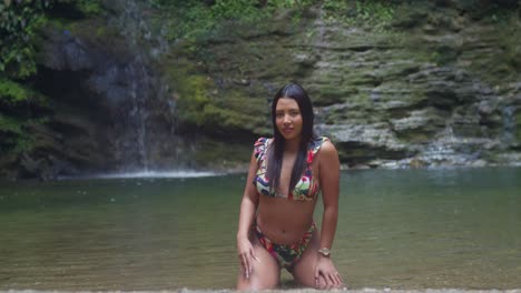 a girl wearing her bikini at a picturesque caribbean waterfall.