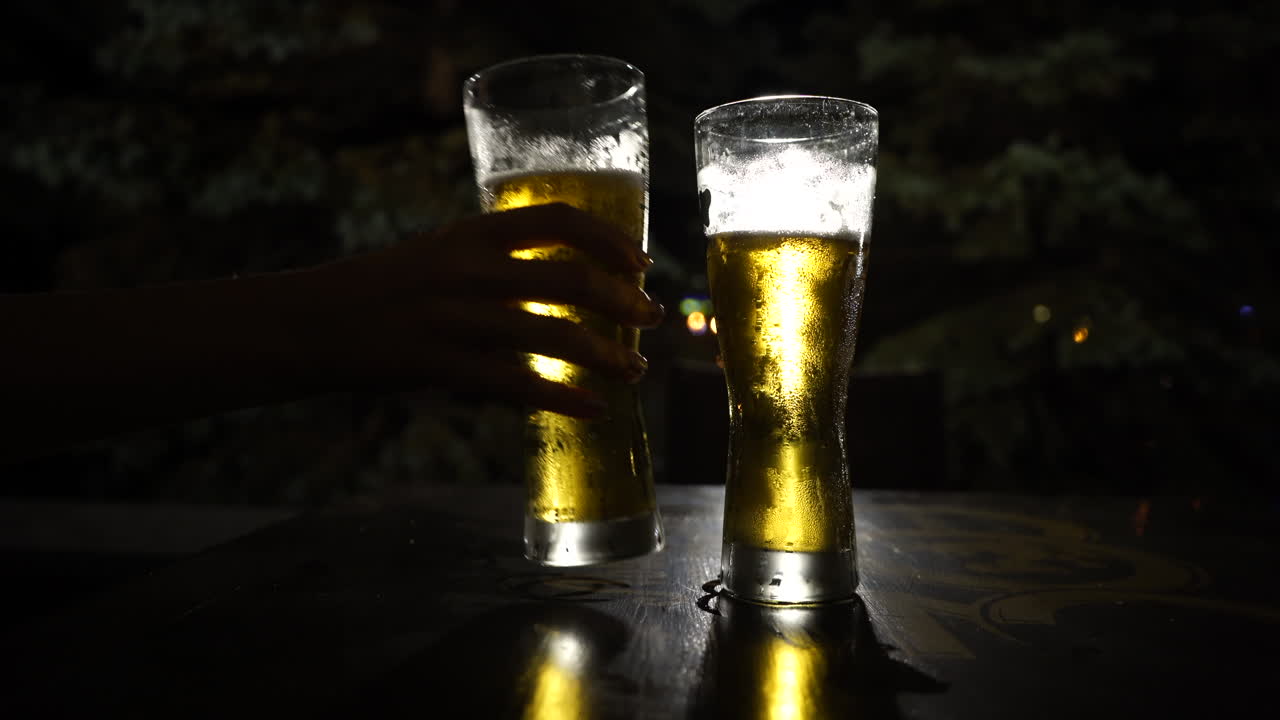 mujer tomando un vaso de cerveza de la mesa y devolviéndolo