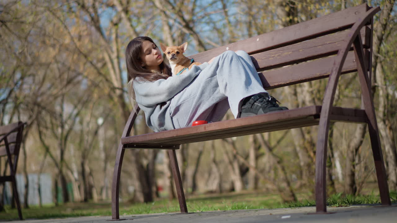 애완동물과 함께 외부에서 휴식을 취하는 평화로운 여성, 밖에서 반려견과 함께 편안하게 앉아 있는 고요한 여성, 친근한 강아지와 함께 자연 속에서 휴식을 취하는 평온한 여성