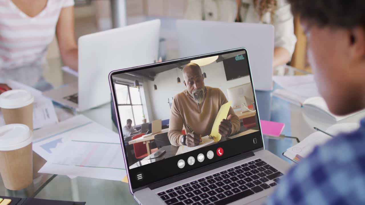 African american man using laptop for video call, with business colleague on screen