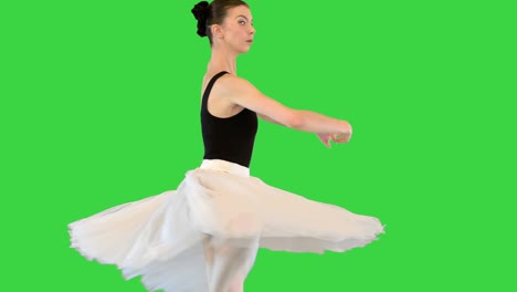 ballerina in a romantic tutu and pointe ballet shoes training fouette on a green screen, chroma key