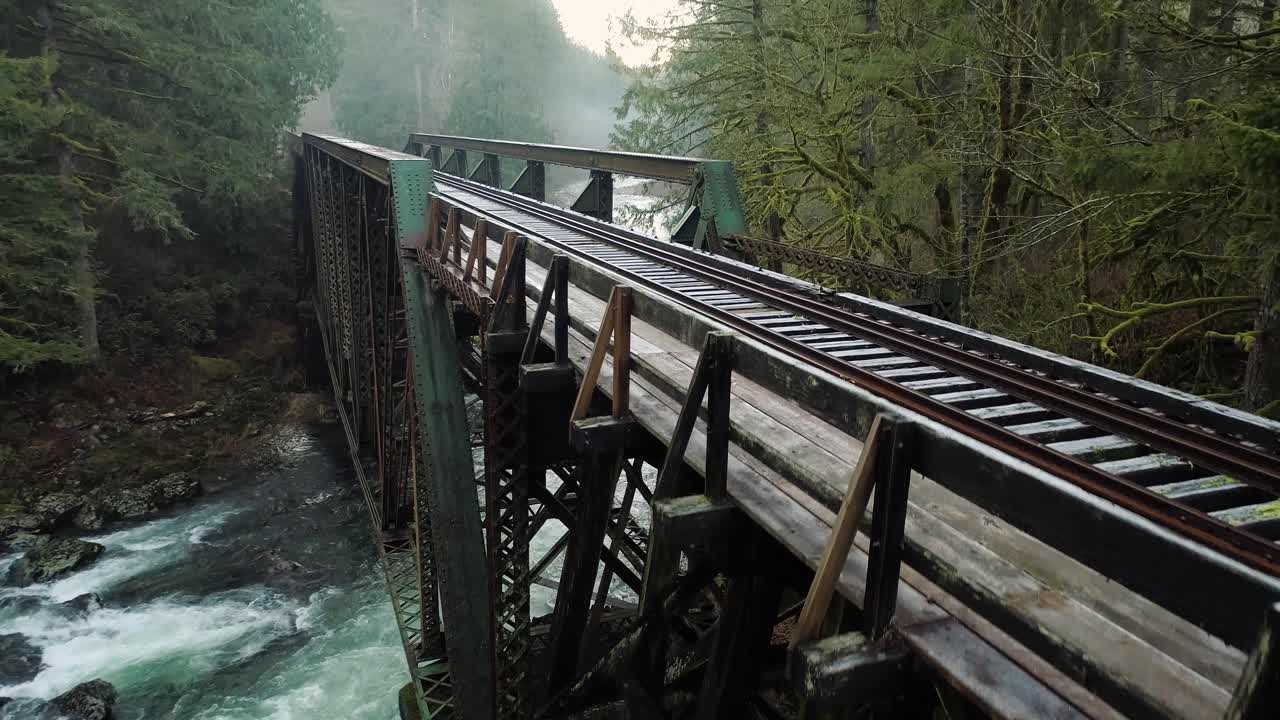 vuelo de escalada sobre la parte superior del puente del ferrocarril que revela neblina en la distancia