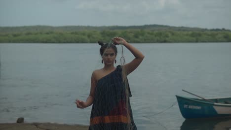 close-up of a concerned woman's face, revealing the littered beaches and disregard for nature, including discarded fishing nets with ocean behind her