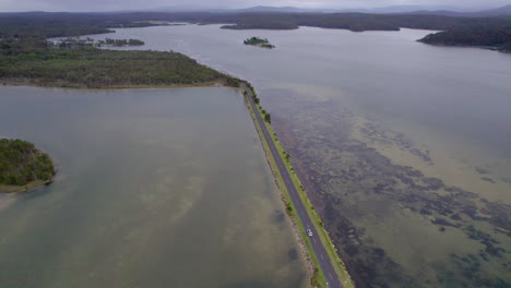 a van crosses the walga lake road bridge in remote australia. scenic aerial view captures the peaceful surroundings and the vast natural landscape of the outback road