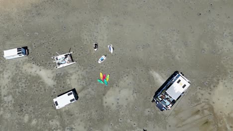 boats stranded on sand, people nearby