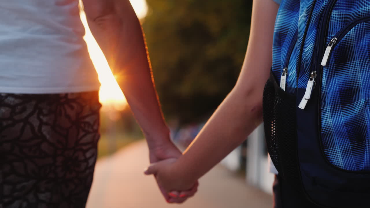 엄마는 아이의 손을 잡고 학교에 데려다 준다