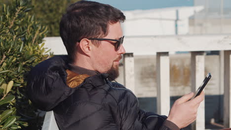 hombre usando un teléfono inteligente al aire libre
