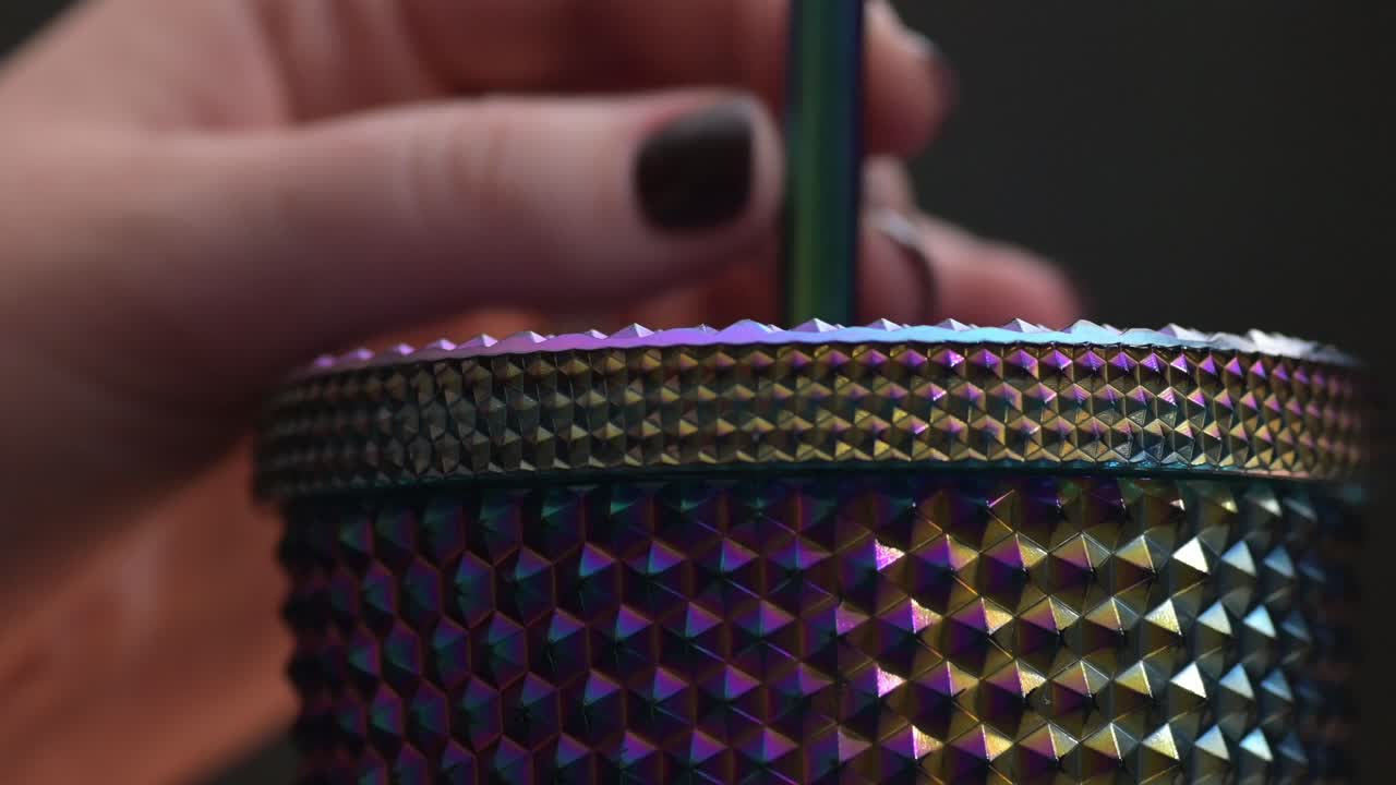 primer plano de mover una pajita en un vaso de bebida fría con bordes