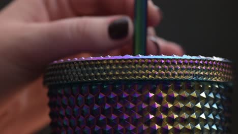 close-up of moving a straw in a cold drink glass with edges