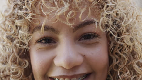 close-up of a young biracial woman smiling at the camera