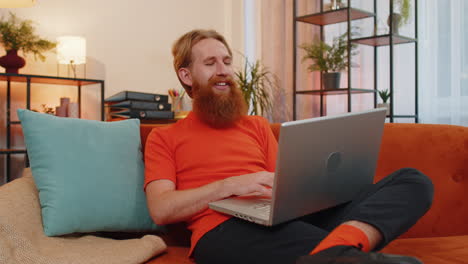 joven freelancer comienza a trabajar en una computadora portátil, envía mensajes, hace compras en línea en casa