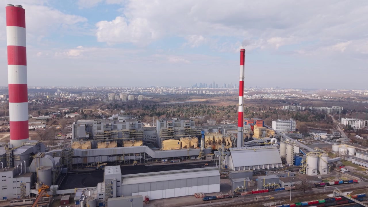 Панорама городского промышленного района. Вид с воздуха на Варшавский промышленный комплекс: городской завод с высокой дымовой трубой и резервуарами.
