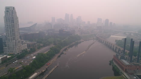 Ariel-Sobre-El-Río-Mississippi-Con-Humo-De-Incendios-Forestales-Oscureciendo-El-Horizonte-Del-Centro-De-Minneapolis