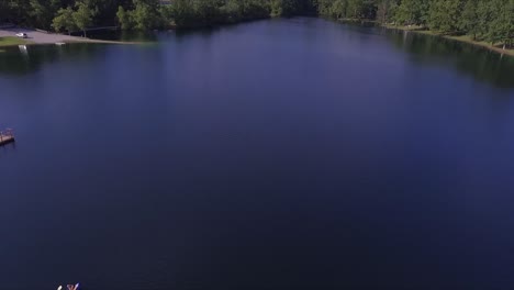 drone flies over kayakers on beautiful lake