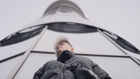 person standing in front of a modern tower