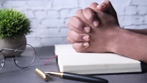 hands in prayer on a book