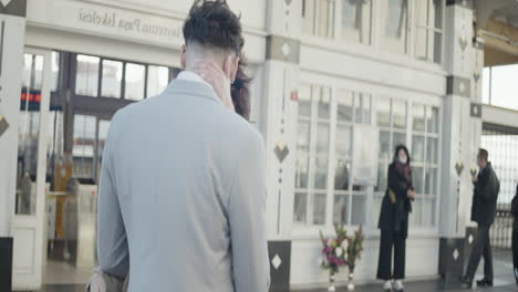 couple kissing at train station