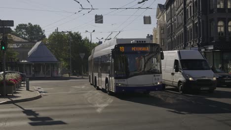 trolley bus driving through streets, pan following shot