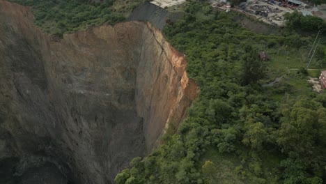 la inclinación aérea revela la escalada de un acantilado de roca vertical en una mina a cielo abierto
