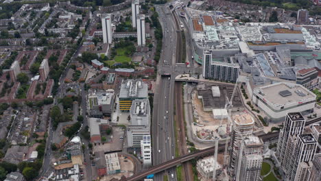 High-angle-view-of-main-road-diverting-traffic-away-from-city.-Urban-neighbourhood-with-classic-development,-tall-buildings-and-shopping-centre.-London,-UK