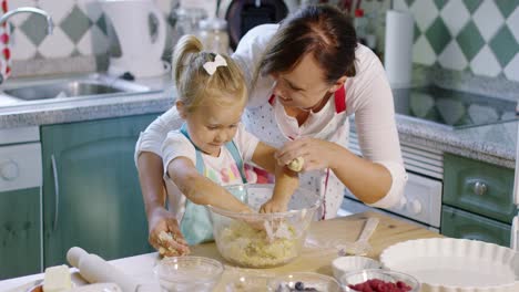 Little-girl-helping-to-knead-the-pastry-dough