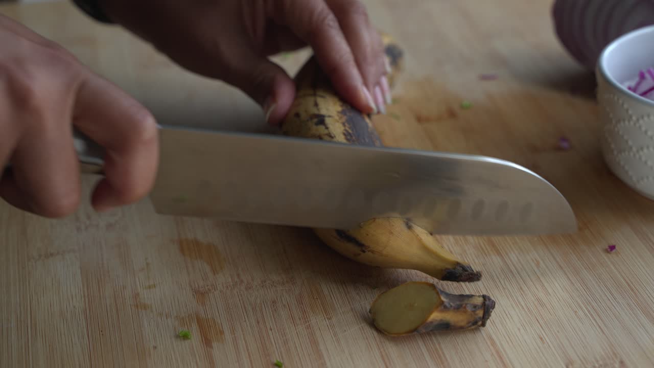 Cutting the tips of a yellow plantain special ingredients to cook a meal two cans of beans rice plantain avocado red onion and cilantro