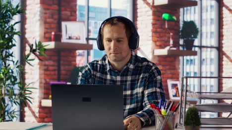 teletrabajador disfrutando de la música mientras investiga datos para un proyecto de la empresa