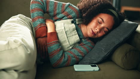woman lying on couch with stomach pain