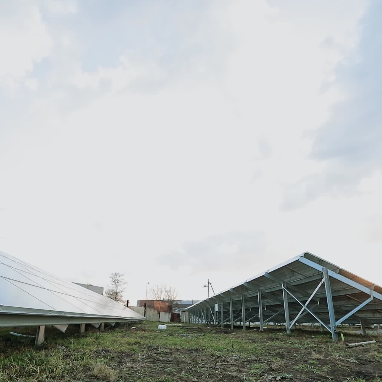 Innovative solar farm. Metal constructions with sunny batteries on the ground. Photovoltaic solar panels produce alternative energy. View from below.