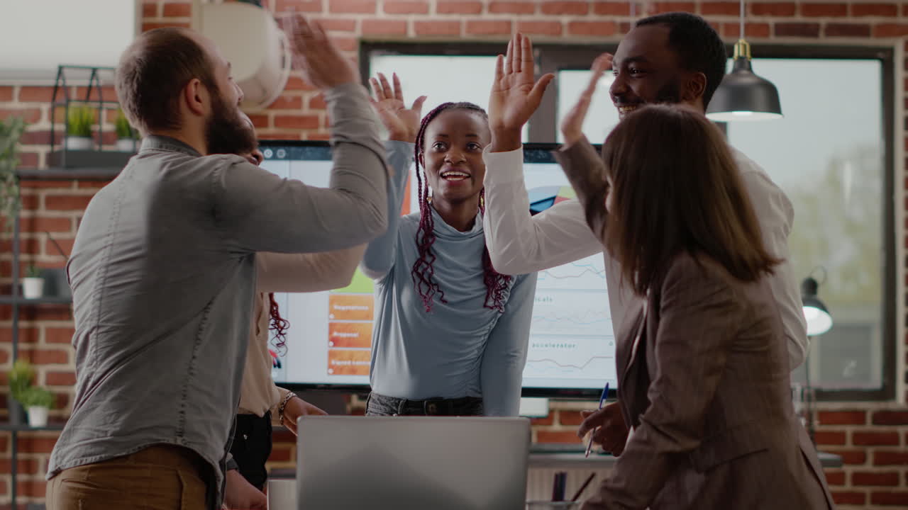 Multi ethnic people joining hands in unity to celebrate success