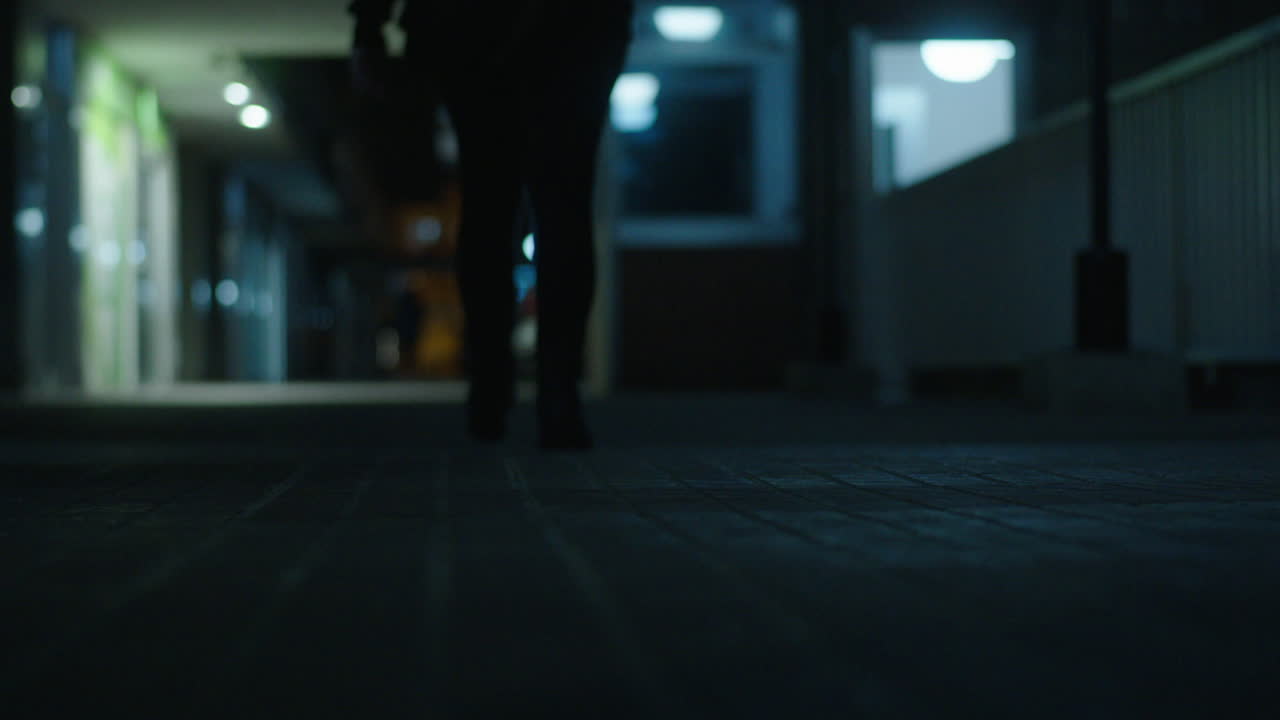 Person Walking at Night in a Corridor
