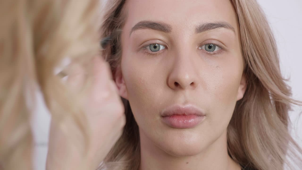 una mujer haciendo su maquillaje.