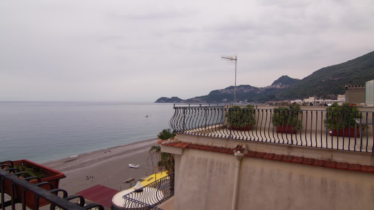 View of the beach and coastal mountains from a balcony in Letojanni, Sicily
