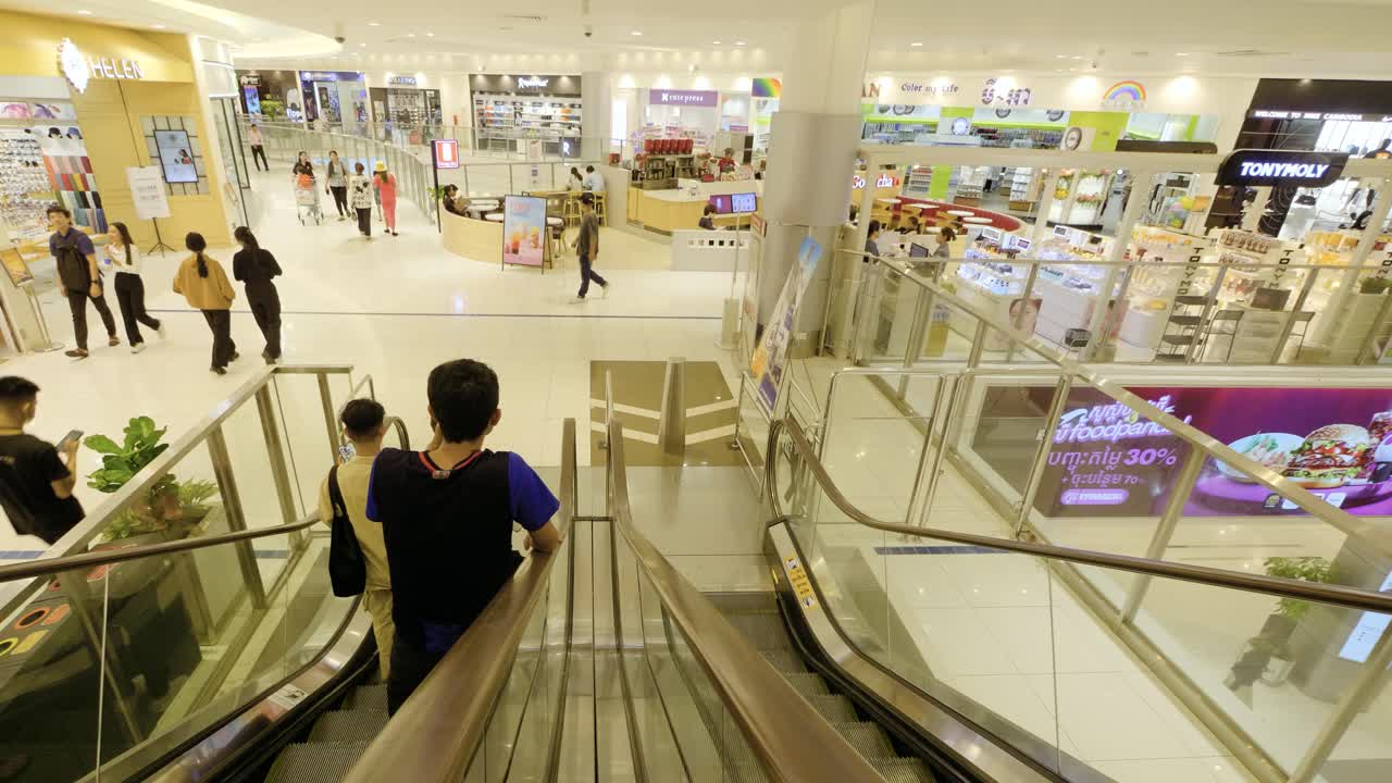 People using electric staircase, escalator to travel between floors of shopping complex