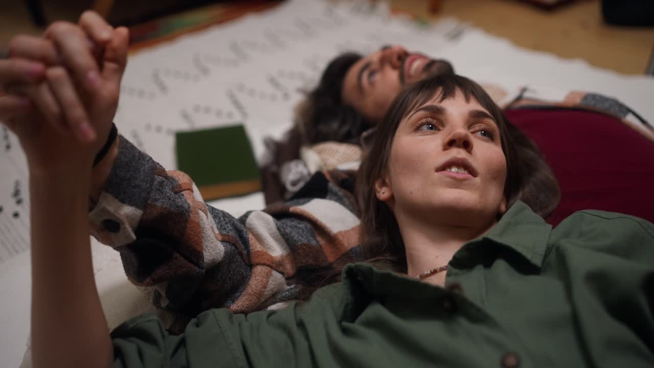 Couple holding hands lying down together