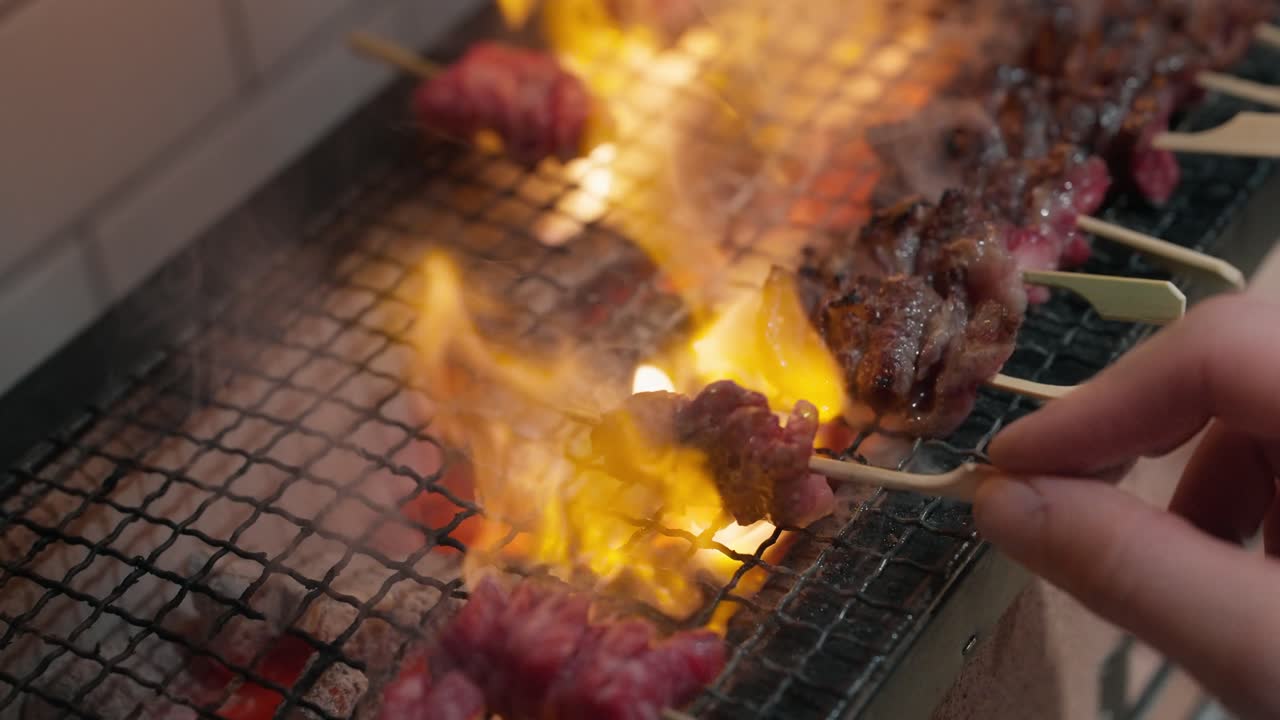 Sate wagyu dibalik di atas api panggangan binchotan (gerak lambat 4K)