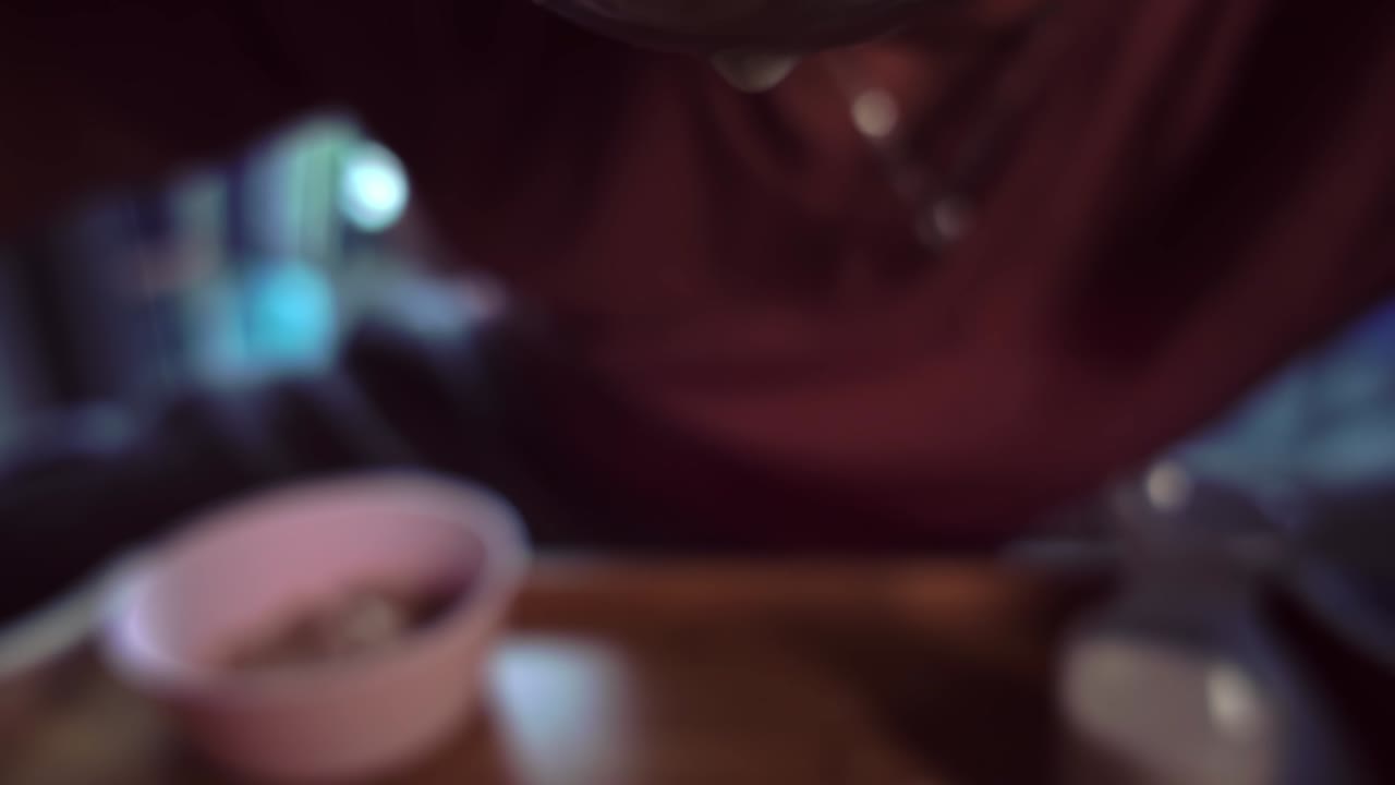 Close-up slow motion shot of a person bringing a spoonful of cereal to their mouth, capturing the eating moment with soft focus and emphasized motion