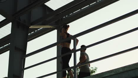 Young-Couple-Of-Joggers-Running-At-The-Stadium-Passage-While-Doing-Sport-In-The-Morning