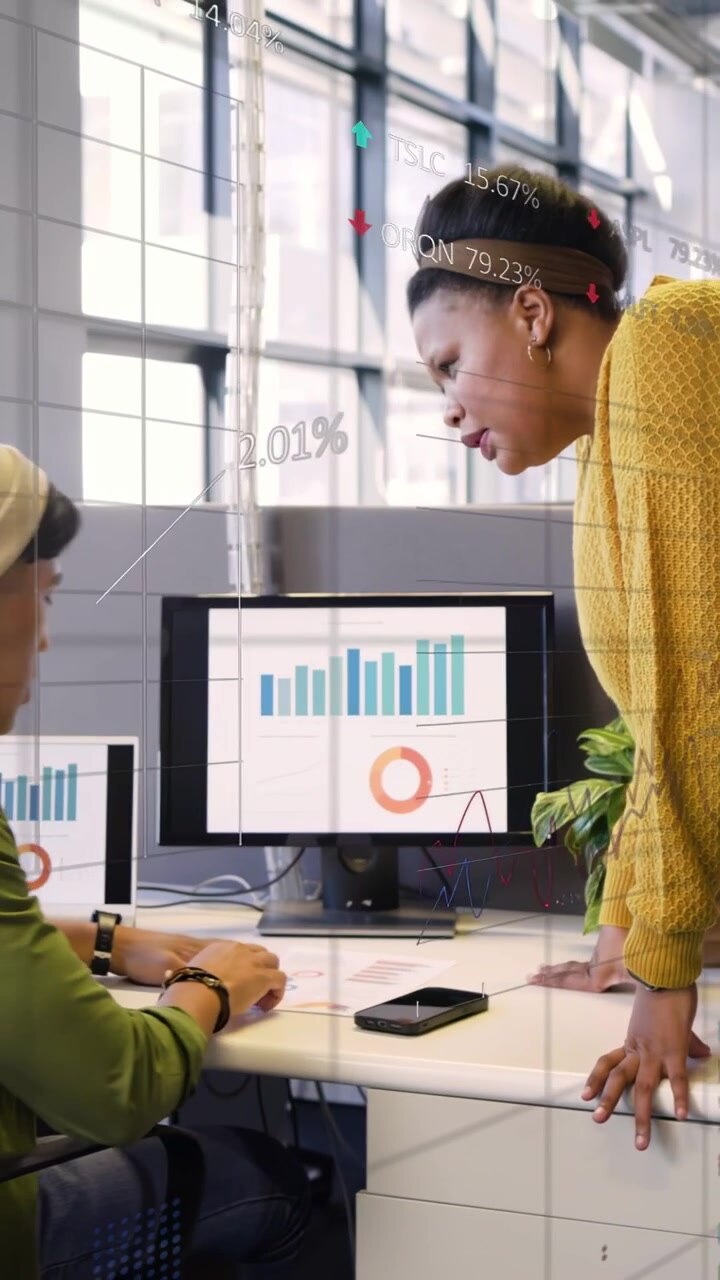 Analyst sorting pages, manager coming, pointing at bar donut charts with tickers, analyzing finance