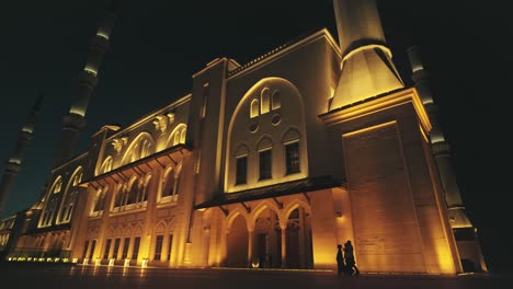 Familia-Musulmana-Caminando-En-El-Patio-De-Una-Gran-Mezquita-Por-La-Noche