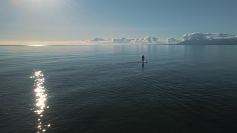 hombre remando en un mar vacío y tranquilo