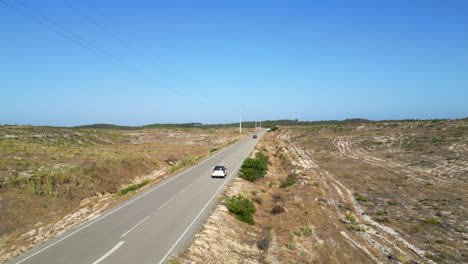 Un-Dron-Sigue-A-Un-Coche-Por-Una-Carretera-Solitaria