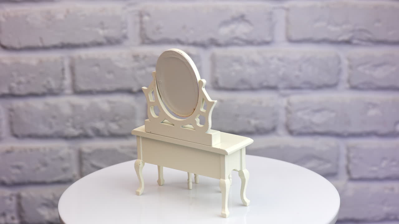 White wooden nightstand with mirror and tiny tabouret. Furniture at the rotating table at white backdrop. Close up.