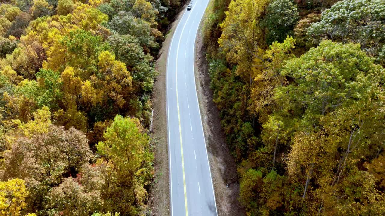 antena aérea de automóviles a lo largo de la carretera con follaje de otoño y otoño