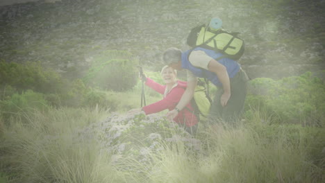 happy caucasian senior couple hiking in countryside over rays of light