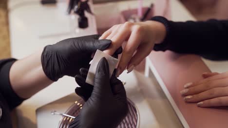 closeup of manicure master wipes his nails