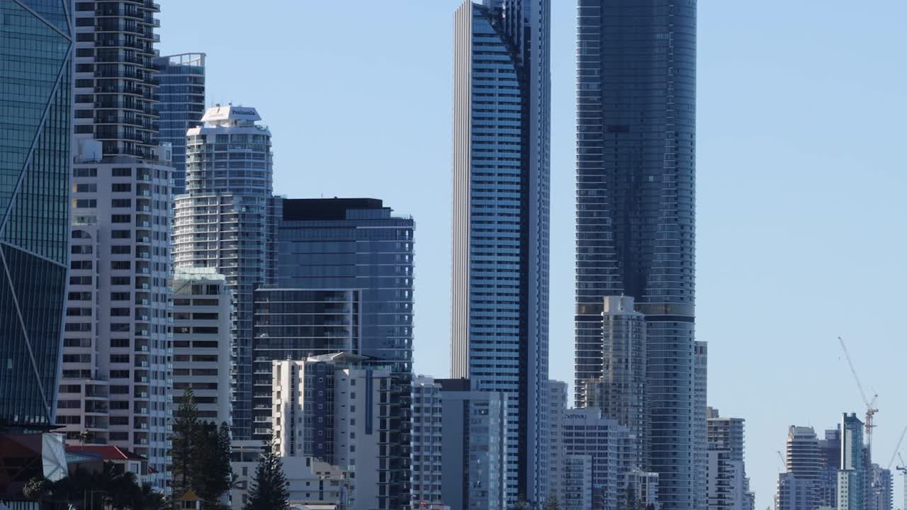 A view of towering skyscrapers against a clear blue sky in a bustling urban area.