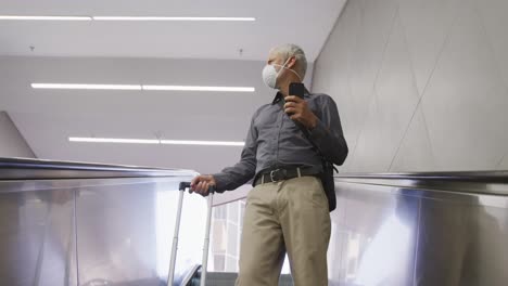 caucasian man out and about in a metro station wearing on a face mask against coronavirus