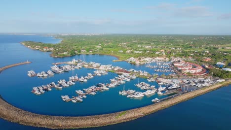 aerial flyover luxury marina with parking yachts and boats in la romana during sunset - dominican republic island