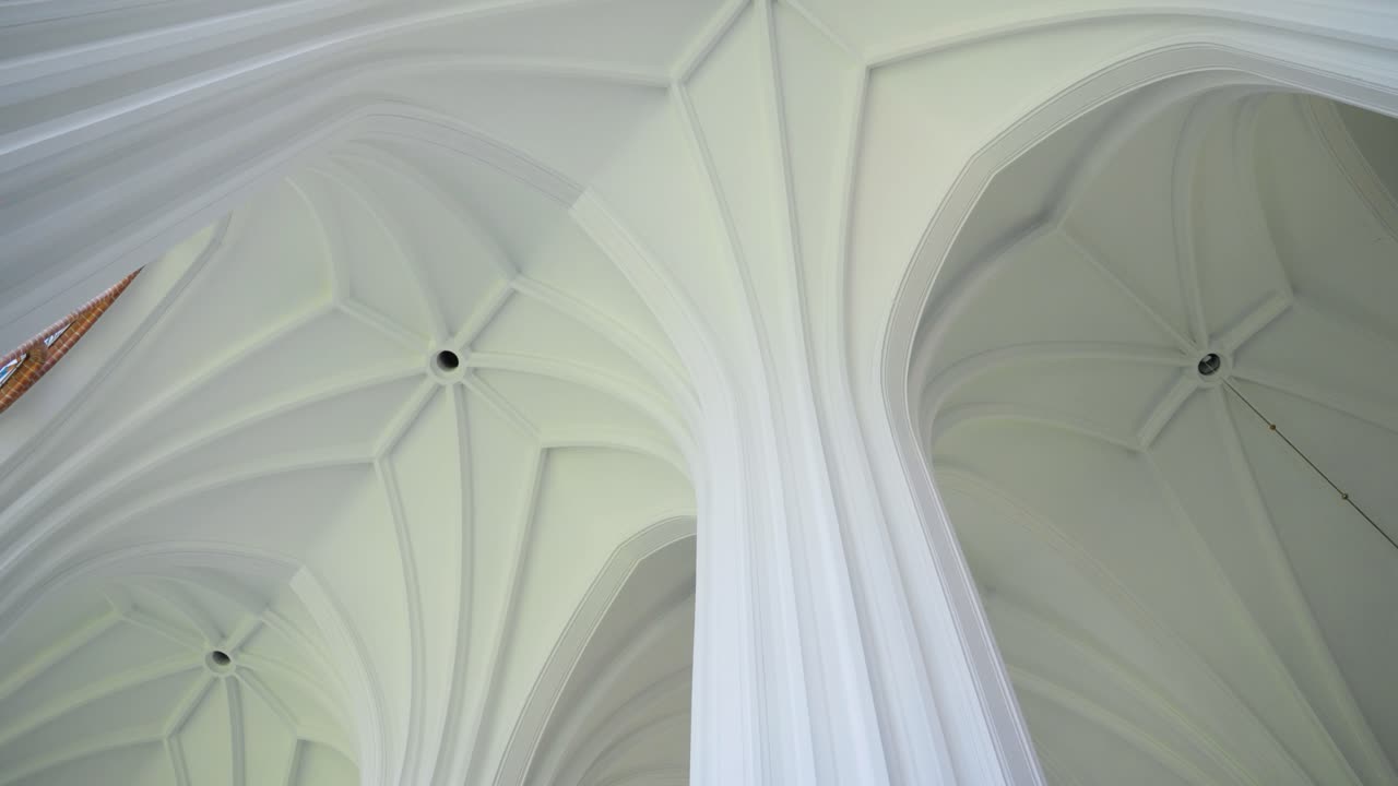Low angle of white ceiling and pillar of the church of Saint Mary's Scapular in Druskininkai, Lithuania